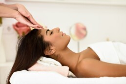 Woman receiving head massage in spa wellness center.